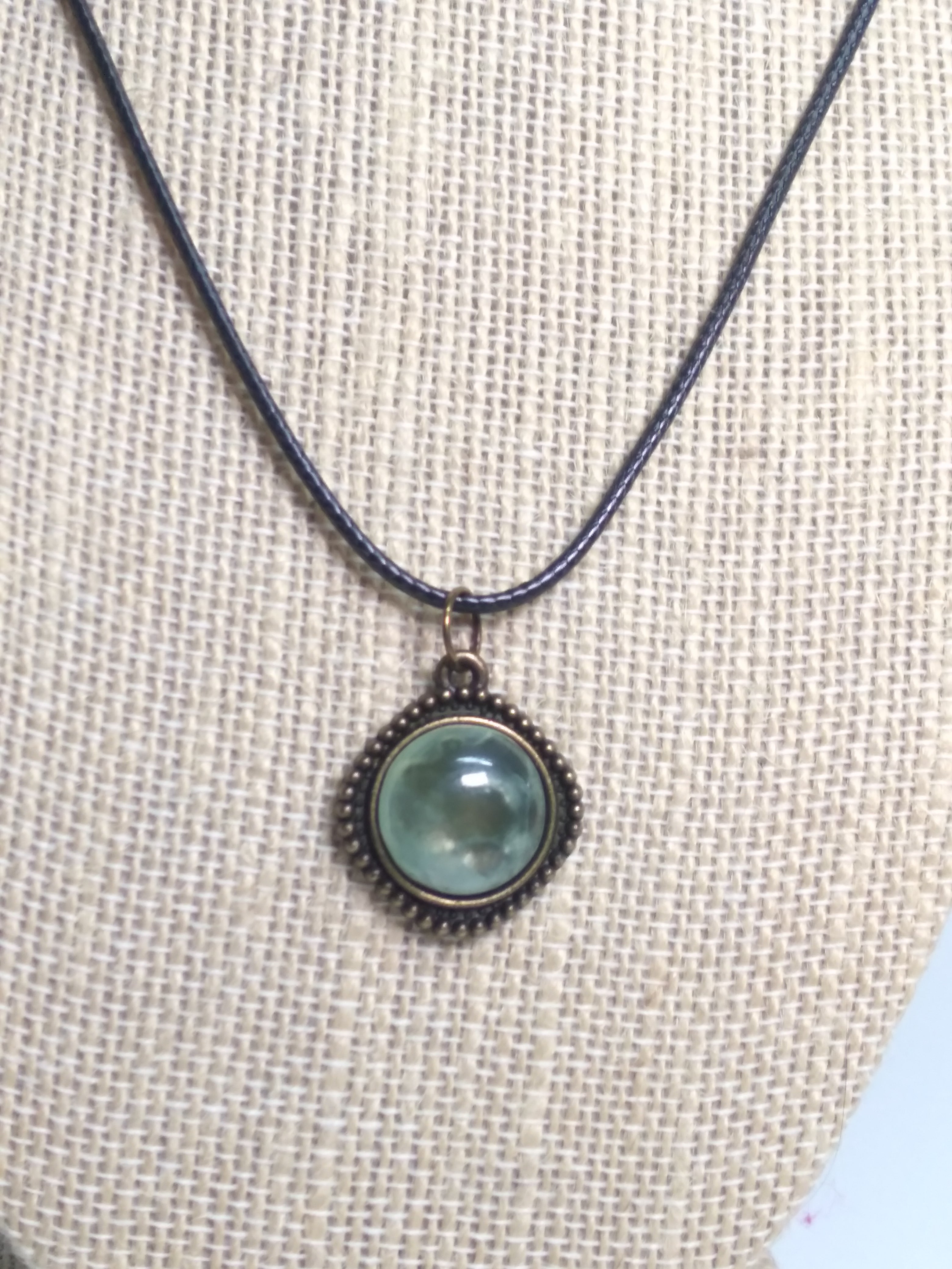 Round prehnite pendant on black cord